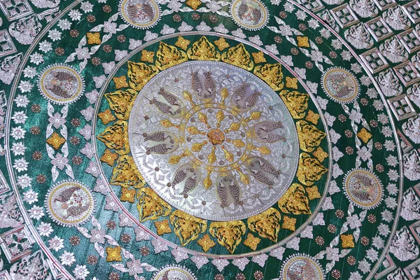 Merkezi saat tasarımı ve karmaşık detaylarla süslü yeşil ve altın dairesel mozaik zemin deseni. Eski sanat ve işçiliğin lüks ve görkemli bir örneği.