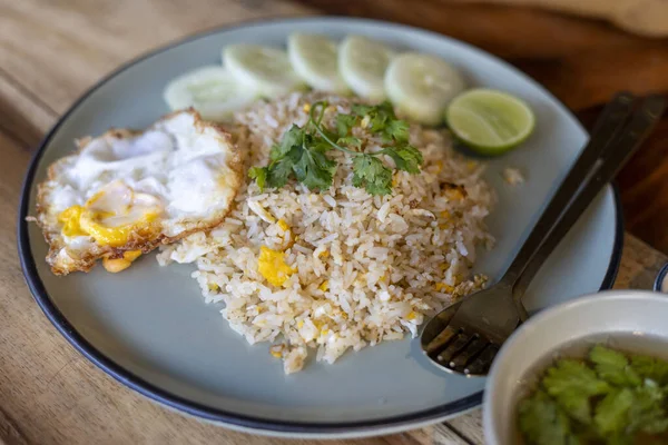 Lezzetli ve lezzetli bir tabak Tayland pilavı, ayrıca Khao Pad olarak da bilinir, kızarmış yumurta, salatalık dilimleri ve limon dilimleri ile servis edilir. tam Asya yemeği