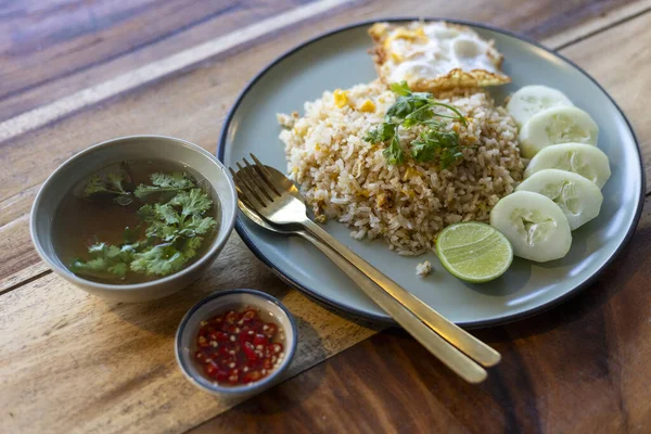İştah açıcı bir tabak Tayland pilavı, lezzetli Asya yemeği kızarmış yumurta, salatalık ve limon. Bu lezzetli yemek sıcak çorba ve baharatlı acı sos içeriyor.