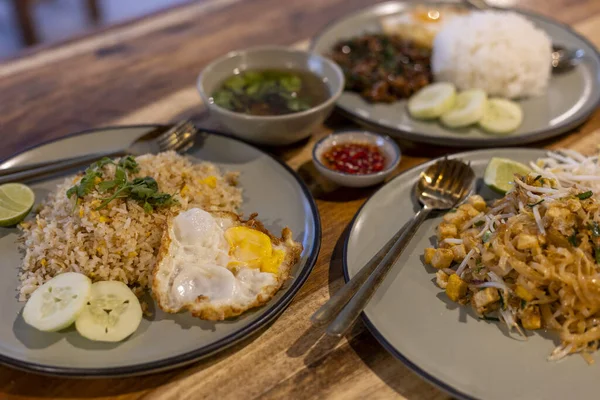 Öğlen ya da akşam yemeği için lezzetli Tayland yemekleri. Restoranda servis edilen yumurtalı pilav, erişte yemeği ve fesleğen kızartması da dahil olmak üzere otantik yemek.