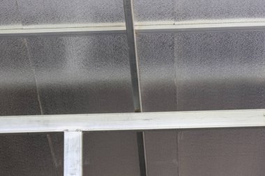 Çağdaş mimari için endüstriyel model materyal ve basit yapı detaylarını gösteren geometrik çizgileri gösteren şeffaf plastik tavan yüzeyine sahip soyut gri metal çatı yapısı