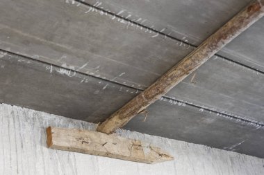 İnşaat sürecinde katı ham dokuyu ve endüstriyel yapı yapısını gösteren geçici destek olarak eski ahşap kaplamalı pürüzlü beton tavan panelleri