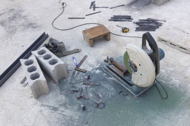 Aktif inşaat alanındaki çelik çubuklu ve beton bloklu ağır metal kesme makinesinin hava görüntüsü ham endüstriyel atmosferi gösteriyor.