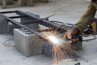 Endüstriyel kaynakçıları kapatın. Çelik kaynakçı, havada uçuşan kıvılcımlar oluşturun. Kararlı bir atmosfer yaratın.