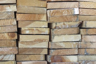 Soyut ahşap kalıplar, doğal dokuyu ve kereste taneciklerini koyu kahverengi tonlu ve sağlam atmosferli kaba depolama deposunda gösteriyor.