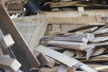 Bir yığın eski ahşap ahşap ve kaba kereste yığını dağınık bir yığın halinde, terk edilmiş inşaat malzemelerini temsil eden kırsal kahverengi renkte kaotik endüstriyel dokuyu gösteriyor.