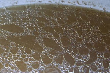 Yakından bakınca yağlı tavuk çorbası ya da yağ köpükleriyle dolu et suyu yüzeyi zengin dokuları ve leziz ev yapımı pişirme stokları için lezzetli altın sıvıları gösteriyor.