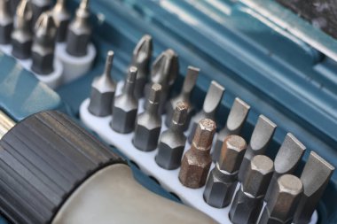 Organize metal tornavida bitinin hassas mekanik tamir işi veya ev geliştirme için uygun mavi plastik alet kutusuna yerleştirilmiş görüntüsünü kapat