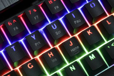 Renkli RGB arka planına sahip canlı bir oyun klavyesi. Modern bilgisayar teknolojisi çevresel gösteriler eğlence ve esalat için dinamik kurulum