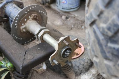 Aracın tamiri sırasında fren diski rotorlu kirli dörtlü motor arka dingil merkezi montajı. Eski otomotiv parçalarının mekanik bakımı endüstriyel bir garajda ya da atölyede