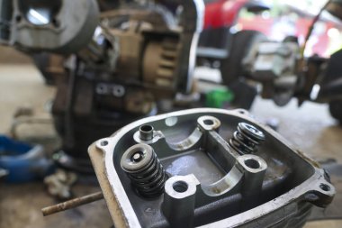 Motosiklet motorunun silindir kapağının iç kapak bileşenleriyle detaylandırılmış hali. Atölyedeki onarım ve bakım hizmeti sırasında mekanik parçalara odaklanmış görünüm