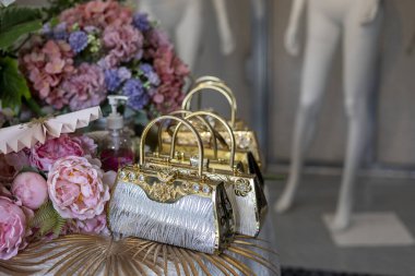 Renkli çiçek buketli gösterişli altın ve gümüş çantalar. Görkemli ve zarif moda aksesuarları klasik, klasik stili çağrıştırıyor.