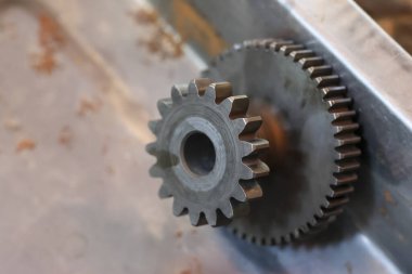 Endüstriyel aşınmayı gösteren eski bir metal şanzıman mekanizmasını kapatın. Paslı makine dişlisi mühendisliği, bağlantıyı, gücü ve takım çalışması kavramını temsil ediyor.