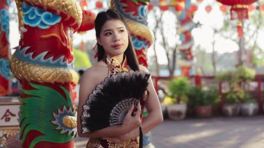 Güzel Asyalı kadın Çin tapınağında geleneksel moda kostümü giyiyor. Ay Yeni Yılı Festivali 'nde kültürel kutlama için çok dingin görünüyor.