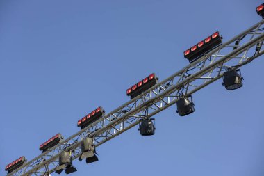 Açık hava sahne aydınlatma ekipmanları açık mavi gökyüzünün altında metal kiriş üzerinde. Konser veya etkinlik için profesyonel kurulum büyük gösteri için beklenti yaratıyor