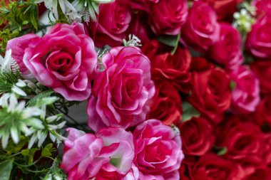Kırmızı ve pembe gül süslemeli romantik yapay çiçek buketi. canlı ve güzel bir çiçek arkaplanı, herhangi bir olay veya kutlama için aşk duygularını ifade eder.