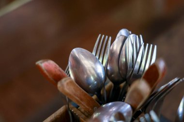 Kırsal metal çatal bıçak takımlarını kaşıklar ve çatallarla ısıt. Bu mutfak gereçleri yemek masasında, yemek için hazır.