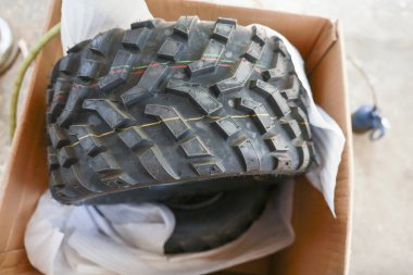 Yeni bir off-road lastiği, saldırgan bir lastik izi, kutuda lastik parçası. Araç bakımı ve hizmet için hazır, boks yapma ve maceraya hazırlanma heyecanı