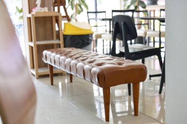 Rahat, uzun, deri bir bank, modern ev dekorasyonunda klasik mobilyalar. Boş ve davetkar bir koltuk huzurlu, şık bir atmosfer yaratıyor.