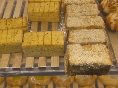 Lezzetli bir pasta ve fırında sergilenen peynirli taze ekmek. Gıda tezgahında satılacak iştah açıcı bir hamur işi.