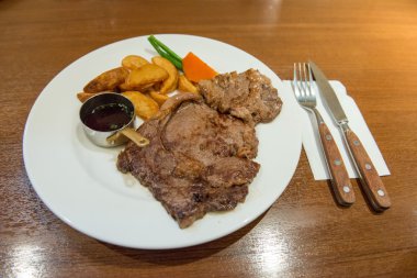 Restoranda bir tabakta büyük, lezzetli bir biftek.