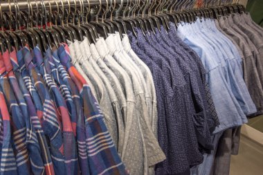  Perakende mağazalarındaki askılarda çok renkli kıyafetler var.