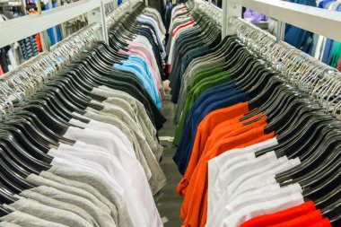  Perakende mağazalarındaki askılarda çok renkli kıyafetler var.