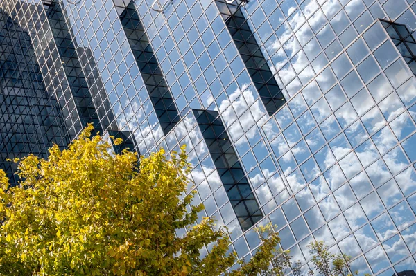 Reflective glass on building mirroring the blue sky