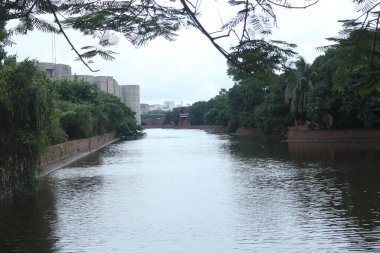 Bangladeş, Dhaka 'daki Parlamento Binası' nın arka manzarası. Parlamento Gölü, bu ikonik milli simgenin etrafında barışçıl ve manzaralı bir manzara yaratan modern mimariyi yansıtır..
