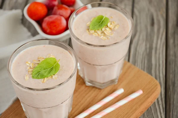 Strawberry and banana smoothie with oatmeal on the rustic wooden table. — Stock Photo, Image