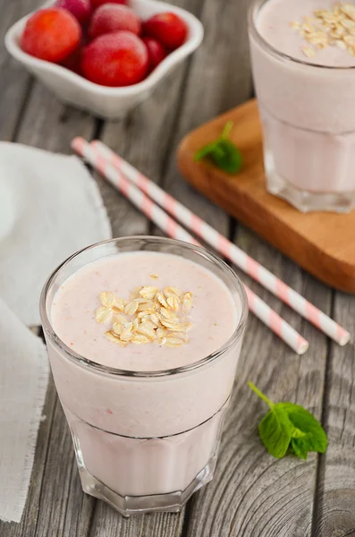Strawberry and banana smoothie with oatmeal on the rustic wooden table. — Stock Photo, Image