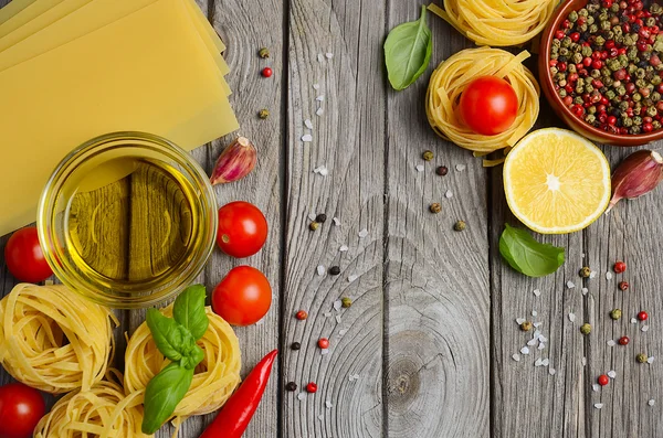 Pasta, grönsaker, örter och kryddor för italiensk mat på den rustika träbord. — Stockfoto