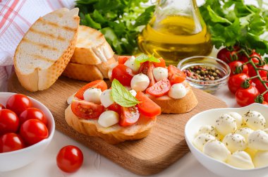 Bruschetta kiraz domates ve mozzarella ahşap tahta üzerinde.