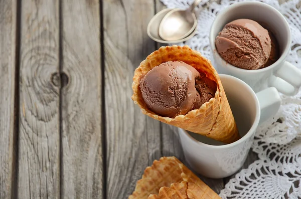 Schokoladeneis in Waffelkegel im rustikalen Holzhintergrund — Stockfoto