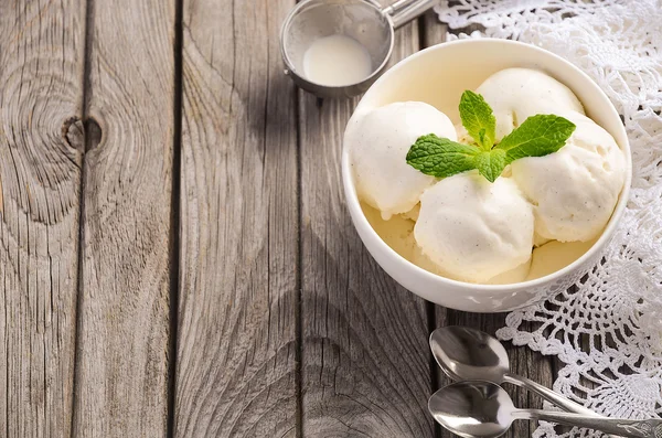 민트와 바닐라 아이스크림 소박한 나무 배경에 흰색 그릇에 나뭇잎 — 스톡 사진