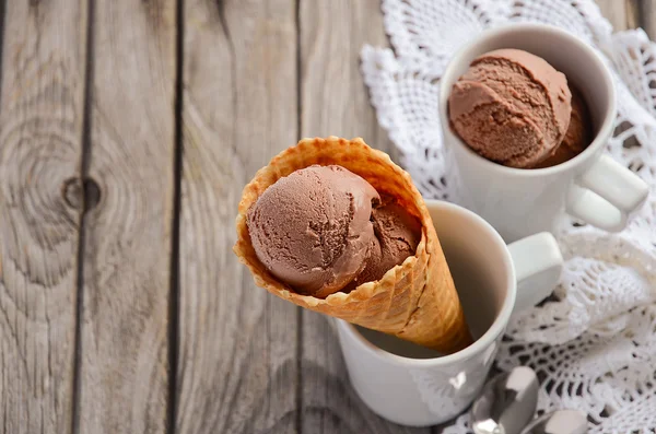 Schokoladeneis in Waffelkegel auf rustikalem Holzhintergrund — Stockfoto