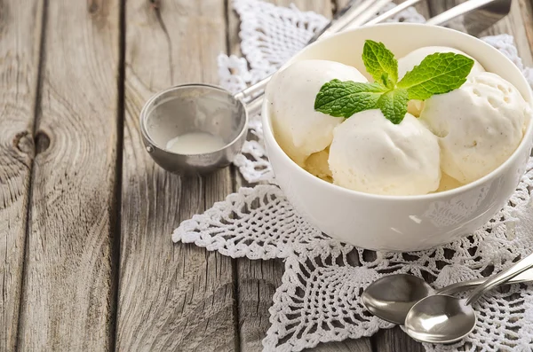 민트와 바닐라 아이스크림 소박한 나무 배경에 흰색 그릇에 나뭇잎 — 스톡 사진