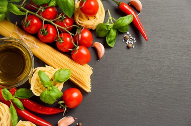 İtalyan yemekleri için siyah arka planda makarna, sebze, bitki ve baharat.