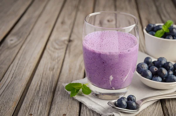 Βακκινίων και μπανάνα smoothie με πλιγούρι βρώμης στο ρουστίκ ξύλινα τραπέζι — Φωτογραφία Αρχείου