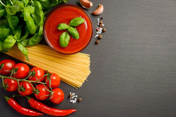 Molho de tomate com macarrão no fundo preto — Fotografia de Stock