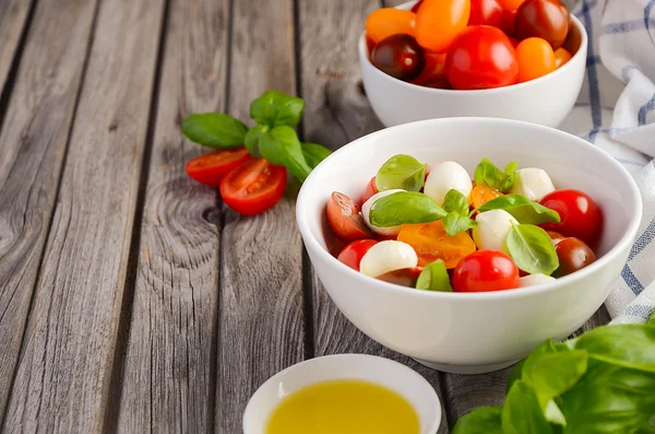 Italian Caprese salad with cherry tomatoes, small mozzarella and fresh basil — Stock Photo, Image