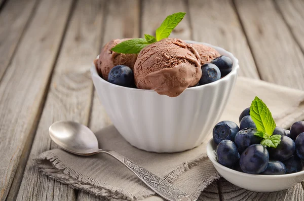 Helado de chocolate en tazón blanco sobre fondo rústico de madera — Foto de Stock