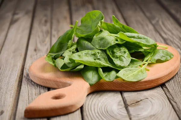 Frische Spinatblätter auf rustikalem Hintergrund — Stockfoto