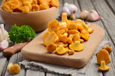 Otlar ve baharatlar rustik ahşap zemin üzerine taze Cantharellus cibarius mantar