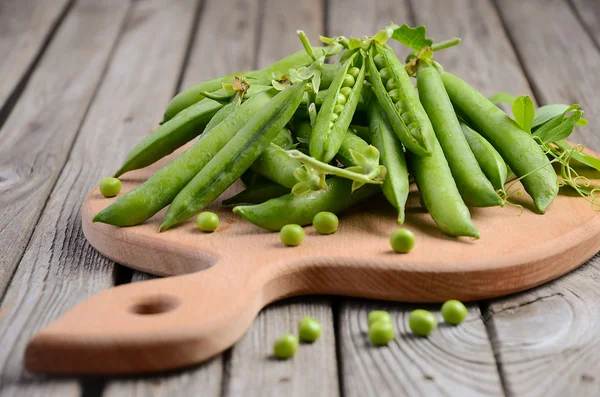 Verse doperwtjes op rustieke houten achtergrond — Stockfoto