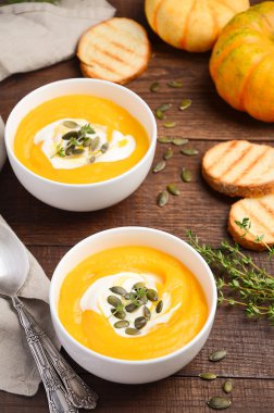 Ahşap arka plan üzerinde krem ve kabak çekirdeği ile kabak kremalı çorba