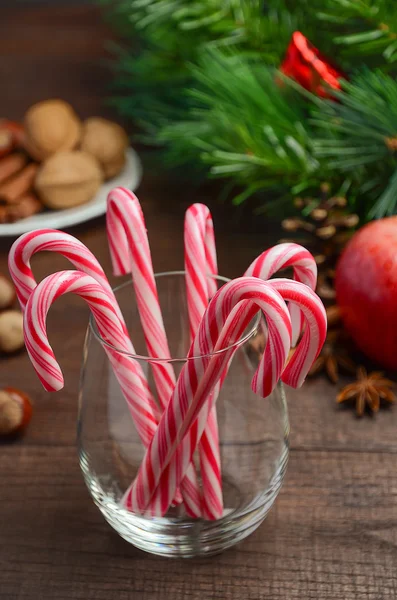 Peppermint Candy Canes and other Christmas decorations on wooden background