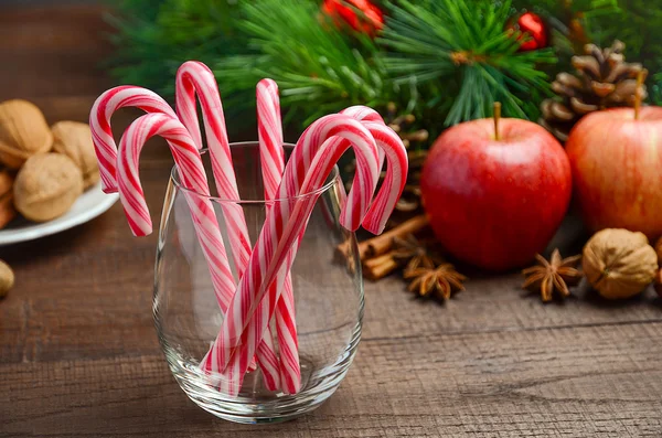 Peppermint Candy Canes and other Christmas decorations on wooden background — Stock Photo, Image