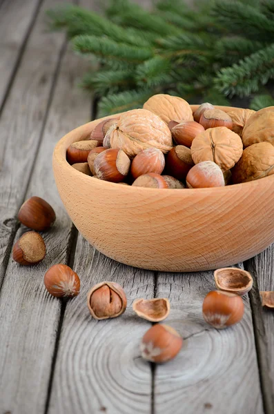 Орехи и грецкие орехи в деревянной чаше — стоковое фото