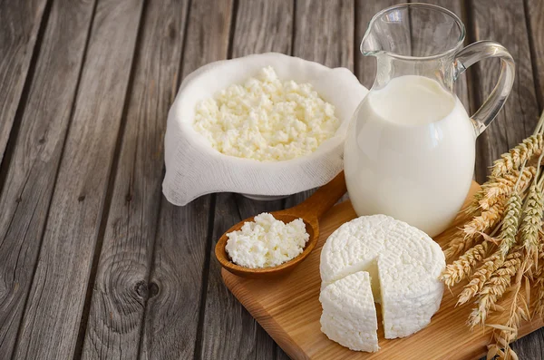 Свіжі молочні продукти. Молоко і сир з пшеницею на сільському дерев'яному фоні . — стокове фото